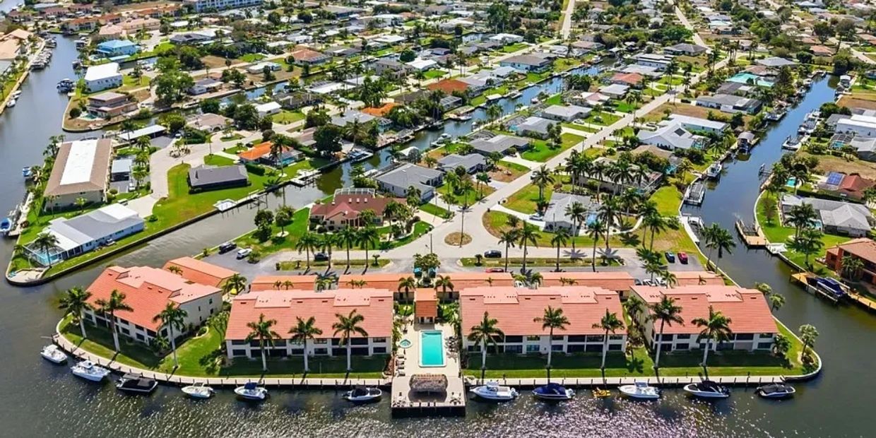 Aerial view of waterfront homes with canals and boats.