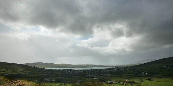 Sky, sea and green fields. Dramatic view of Dingle town and bay from Conor Pass road.