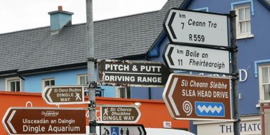 Group of road signs on street for Dingle Way,Pitch and Putt,Slea Head Drive,Aquarium, Ceann Trá, etc
