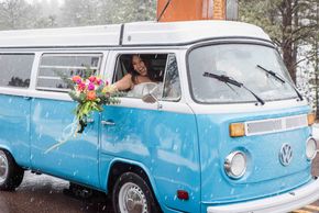 Bride holding bouquet out window of old VW bus