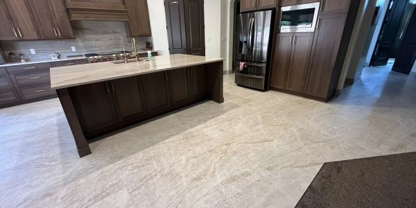 Modern kitchen with brown cabinets and marble floors.