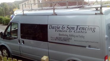 A silver van with fencing business advertisement on the side.