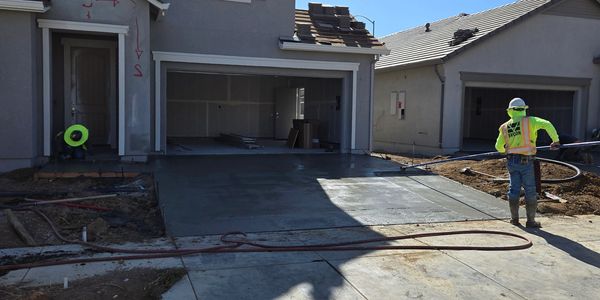 Employee finishing a concrete driveway.