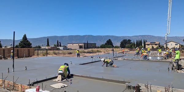 Employees finishing concrete slab.