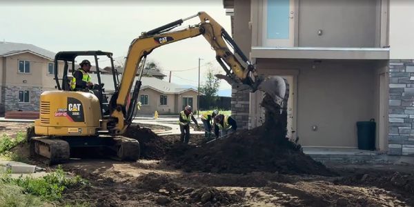 Worker moving dirt with an excavator.