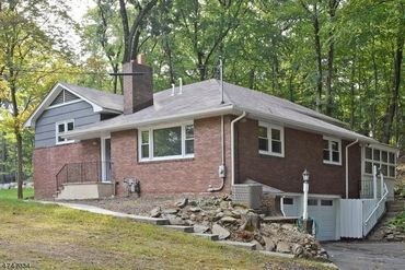 Single-story brick house surrounded by trees.
