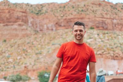 A portrait of a man smiling outdoors with a scenic desert and mountain background in Arizona.