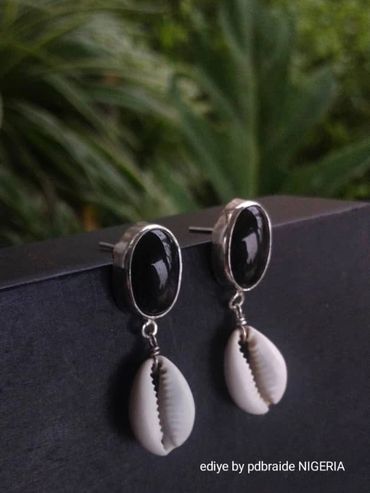 Elegant earrings featuring black stones and white cowrie shells for a chic look.