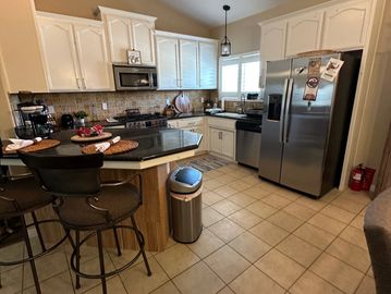 Modern kitchen with white cabinets and stainless steel appliances.