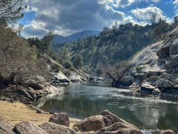 Calm river flowing through a rocky and mountainous landscape.
