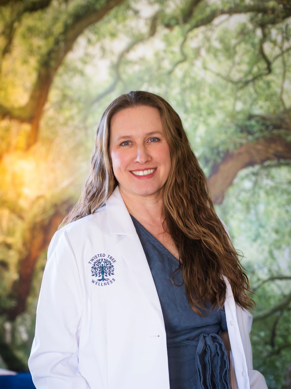 Smiling woman in a white medical coat with a nature background.