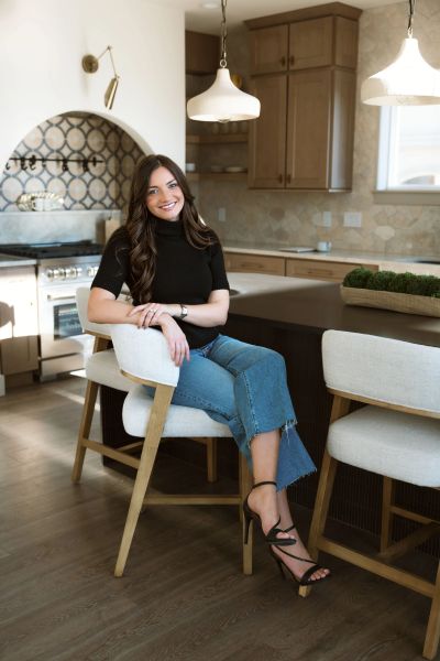 Young woman sitting on a chair in a modern kitchen.