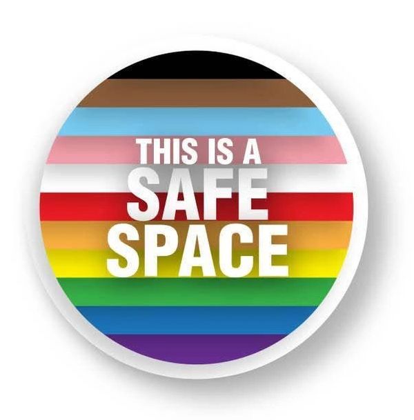 A circular sign with rainbow and trans pride colors, stating "This is a Safe Space."