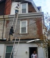 Alex is up on the ladder repairing the back of the three-story home in Philadelphia.