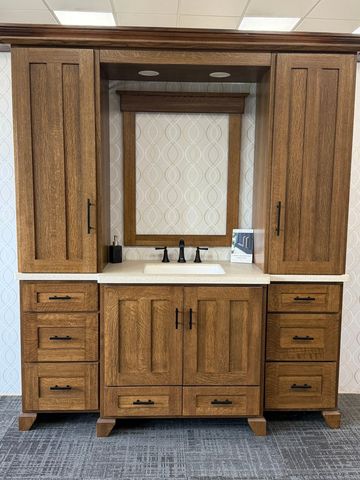 Wooden bathroom vanity with sink and mirror.
