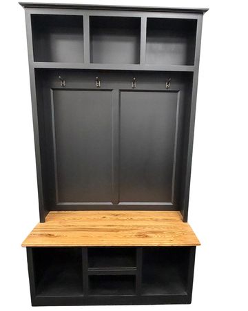 Black and wood entryway storage bench with hooks and cubbies.