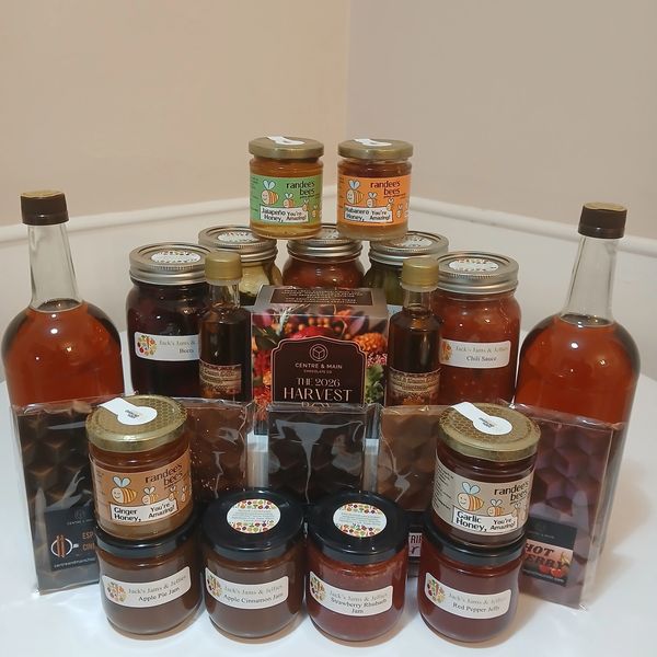 Assortment of jams, sauces, and syrups arranged on a table.