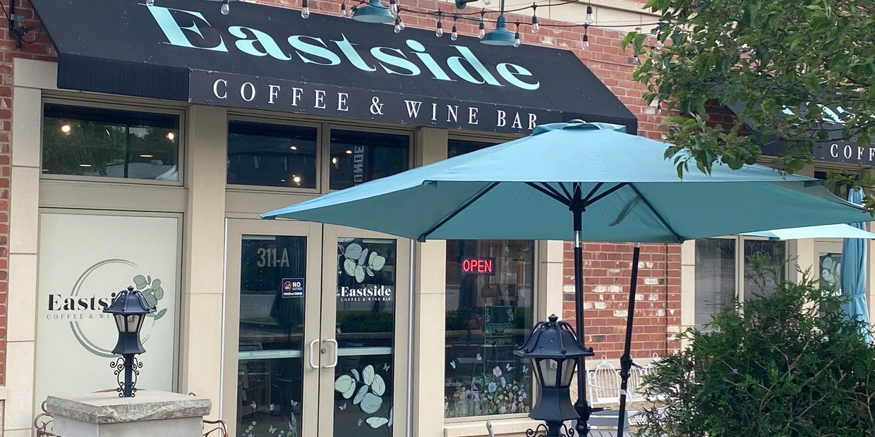 Eastside Coffee & Wine Bar storefront with outdoor seating and umbrella.