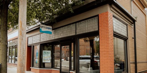 Corner storefront of City2Shore Real Estate with a Black Lives Matter sign in the window.