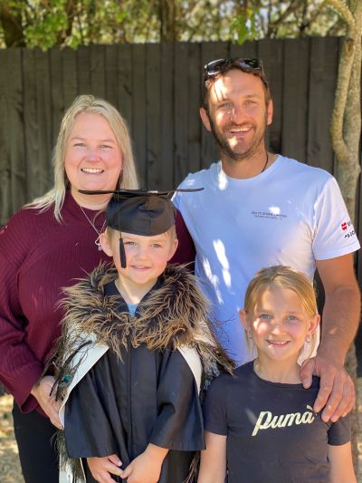 Family celebrating a child's graduation outdoors.