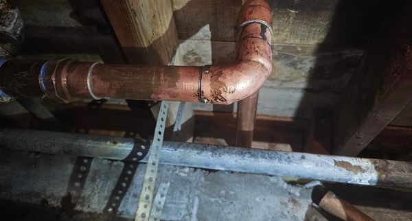 Copper pipes with soldered elbow.