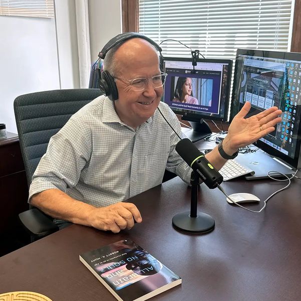 Robert recording a podcast smiling