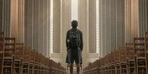 man in church aisle stares up at the sun