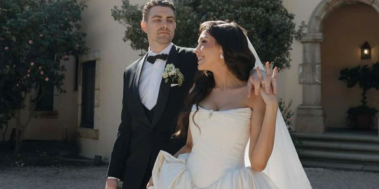 Newlywed couple joyfully holding hands outdoors after their wedding ceremony.