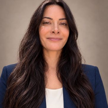 Confident woman with long dark hair in business attire.