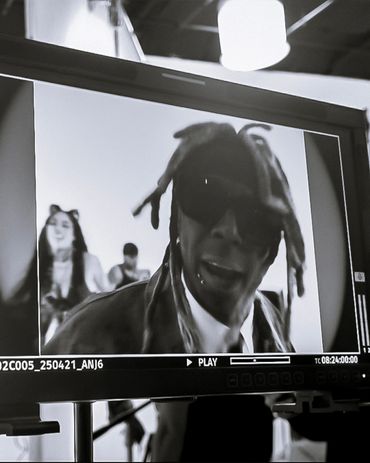 Black and white video monitor shows a man with dreadlocks and sunglasses in front.