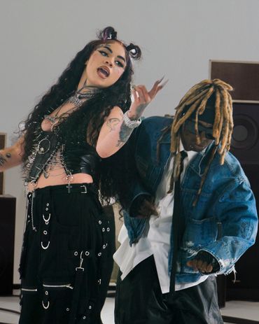 Two stylish individuals dancing with expressive energy in a modern setting.