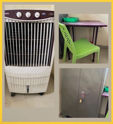 A room corner with an air cooler, green chair, small table, and locked cabinet.