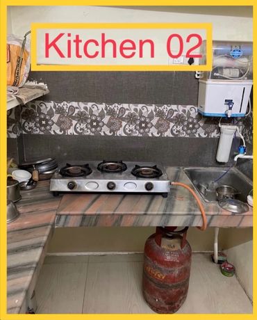 Compact kitchen setup with gas stove and water purifier.