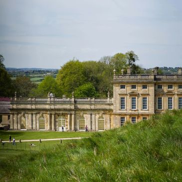 Historic estate with manicured lawns under a partly cloudy sky.