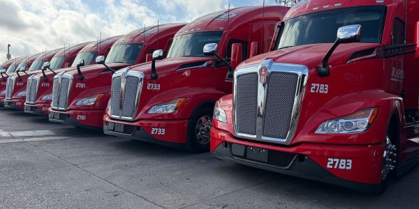 Line of red semi trucks parked side by side.