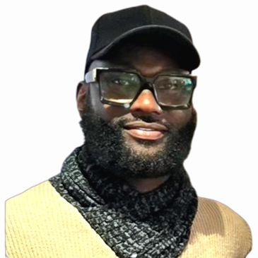 Man with glasses, beard, cap, and scarf smiling.