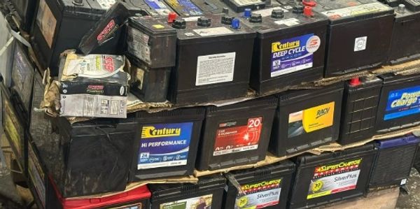 Stack of various car batteries arranged on pallets.