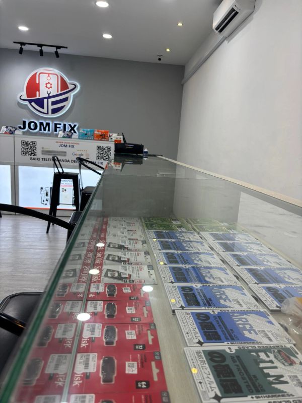 Inside a tech repair shop with accessories displayed under glass.