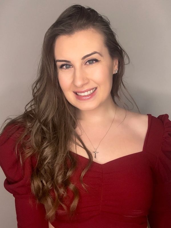 Smiling woman with long hair wearing a red dress.