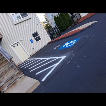 Handicap parking space near a building entrance with clear markings and signs.