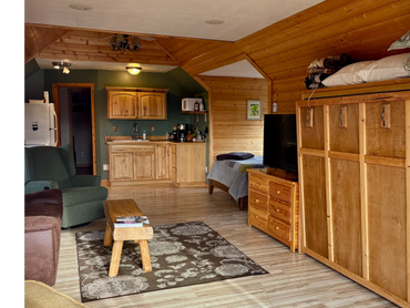 Cozy cabin interior with wooden furniture and a small kitchenette.