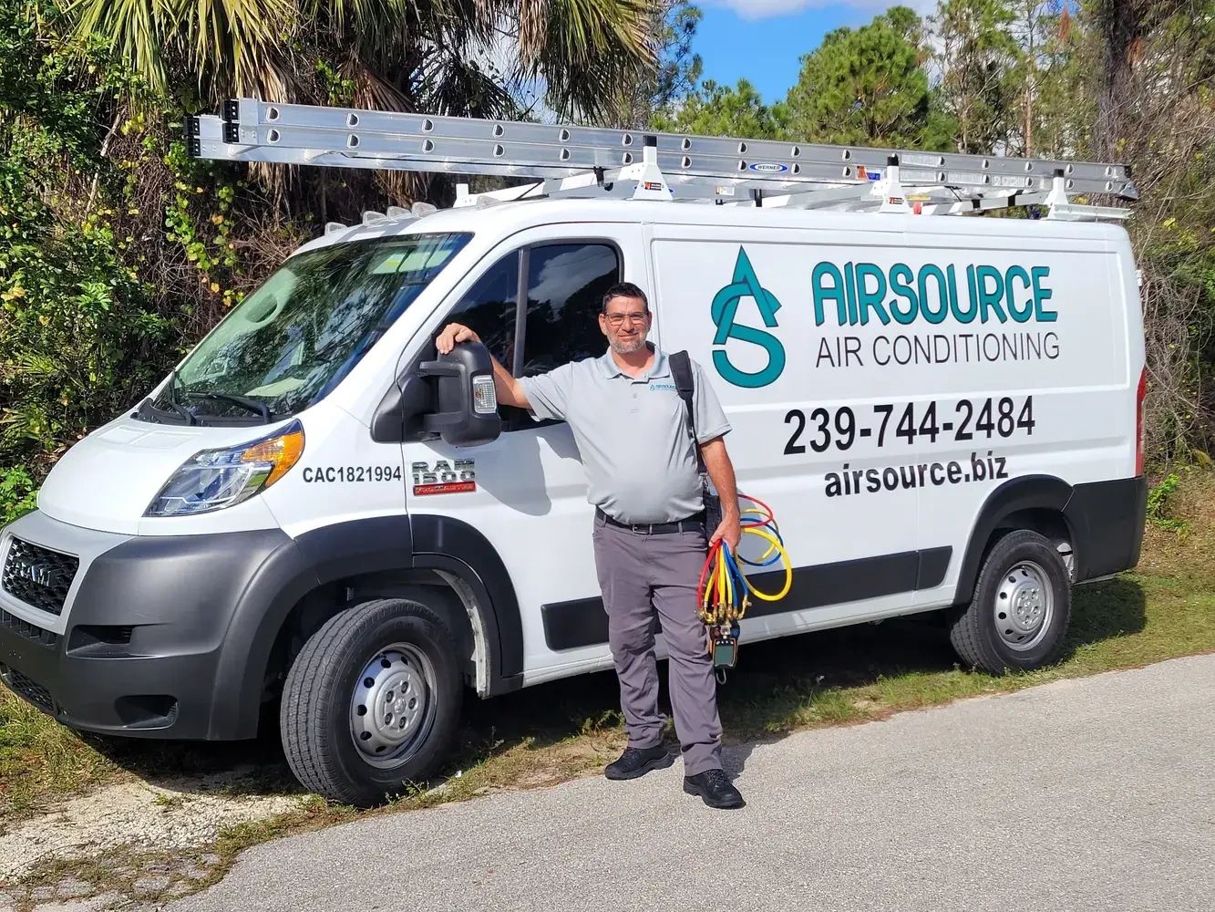 Airsource Air Conditioning technician standing beside a branded service van in Southwest Florida