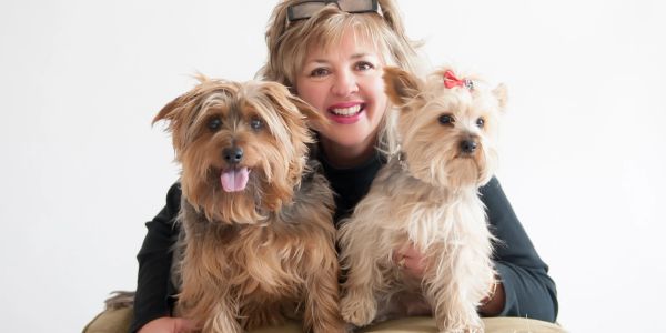 A person hugging two dogs