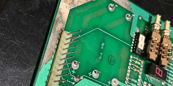 Close-up of a green circuit board with various components and pins.