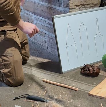 Person kneeling with a whiteboard showing drawings.