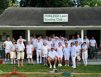 Group photo of lawn bowling club members outside their clubhouse.