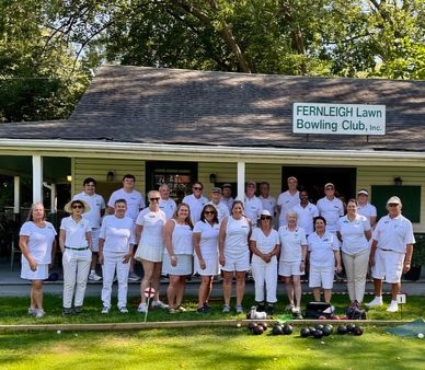 Group of people in white standing outside Fernleigh Lawn Bowling Club.