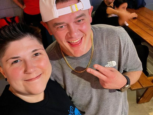 Two friends smiling for a selfie at a casual gathering.