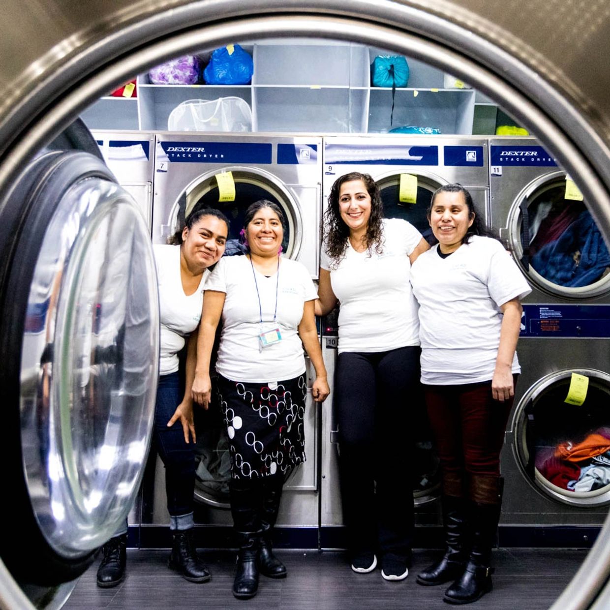 picture of four women taken through washing machine window