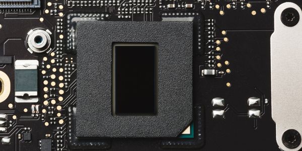 Close-up of a black microchip on a circuit board.